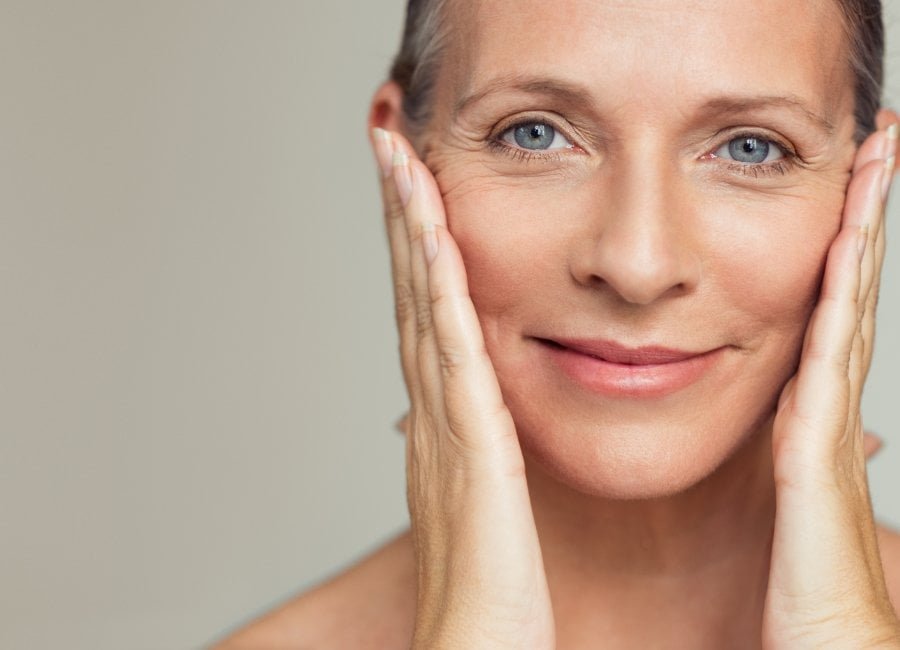 smoothing wrinkles on the face of an older woman