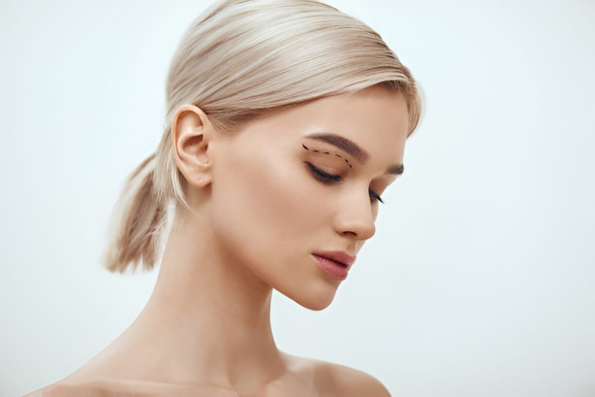 pretty young miami woman with sketch on her face standing against grey background