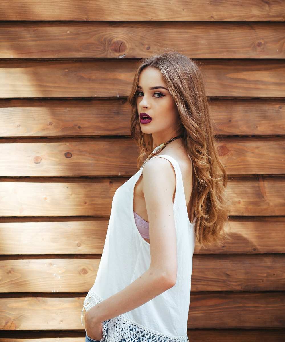 Young girl in white t-shirt posing with wooden background